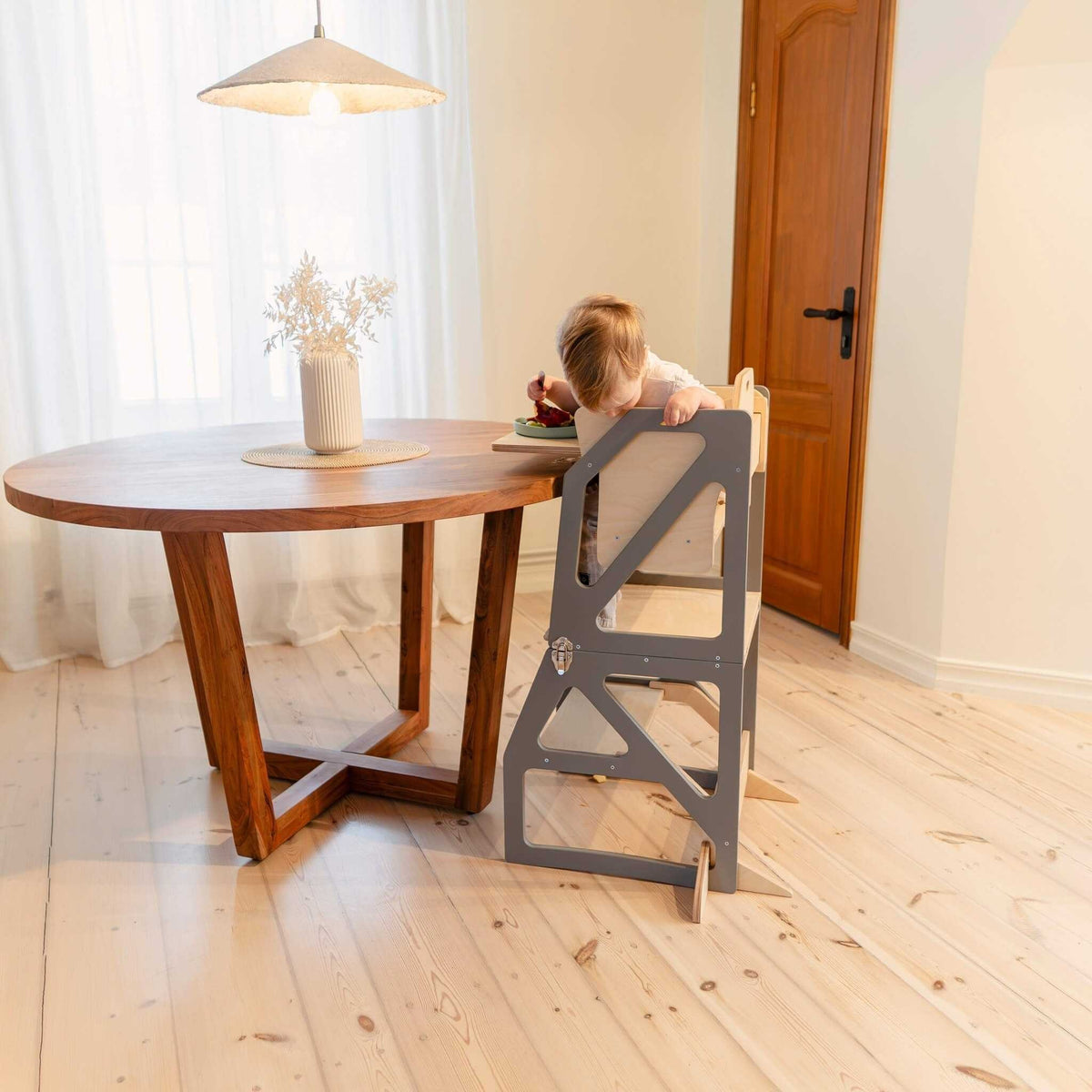 Tour d’observation Modustep avec chaise haute – Un enfant assis sur une chaise devant une table