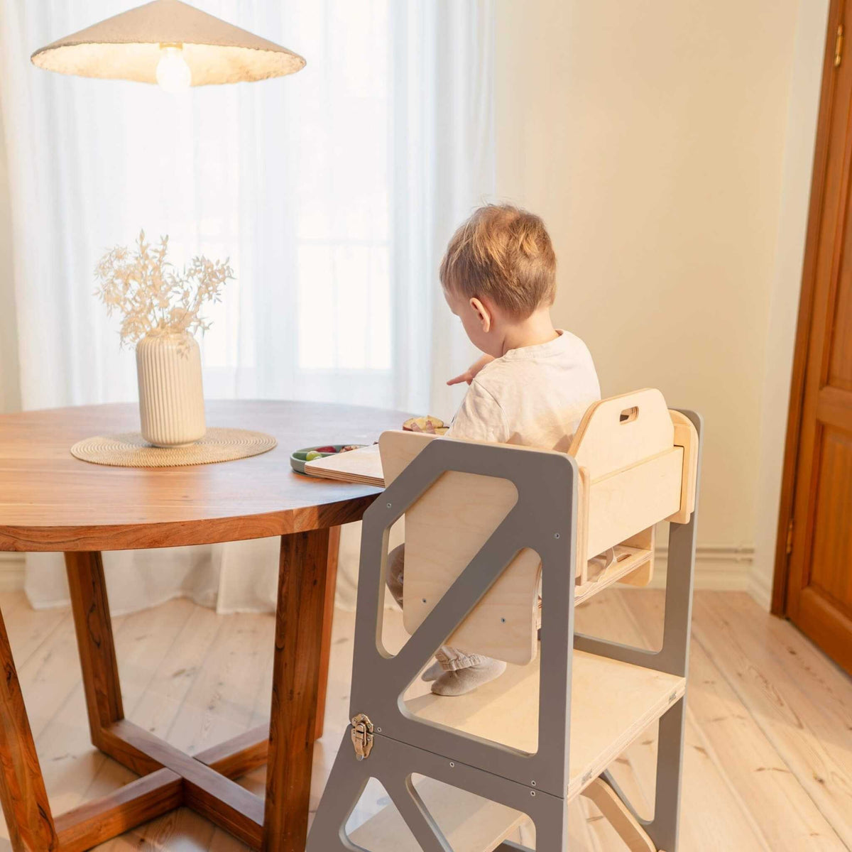 Tour d’observation Modustep avec chaise haute – Un enfant assis dans une chaise haute à une table